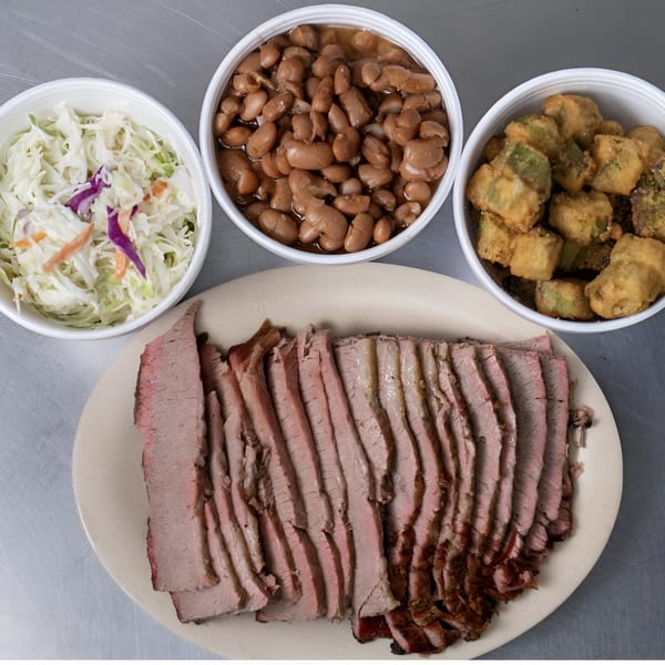 Junior's Barbeque sliced brisket with sides of coleslaw, baked beans, and fried okra.