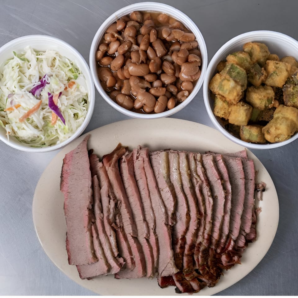 Junior's Barbeque sliced brisket with sides of coleslaw, baked beans, and fried okra.
